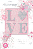 Captured here is a thoughtfully designed anniversary card that blends soft colours and fine detail to evoke a feeling of intimate celebration, perfect for marking another year together in Addington. The centre of the card features the word LOVE rendered in raised, subtly glittering letters. The glitter is delicate and silvery, giving the impression of starlight against a gentle blush-pink sky. The O in LOVE is reimagined as a shimmering heart, slightly more textured and pronounced, symbolising the emotional core of the design. Surrounding this focal word, a scattering of hand-drawn blooms and trailing foliage unfurls across the card, their petals tinted in blush, muted mauve, and creamy white with hints of soft grey. Each flower appears carefully placed, reminiscent of the way a florist might lay out stems on a workbench before tying them into a romantic anniversary bouquet destined for local delivery around Addington. Fine lines, swirling stems, and tiny butterflies fill the spaces between the blossoms, offering a sense of gentle movement and playful grace. The background remains predominantly soft pink, fading into lighter tones that create an airy, almost weightless ambiance. Above and below the central motif, understated script messages-phrases along the lines of On Our Anniversary and I love you today and always-are written in a flowing, elegant hand, their curves echoing the shapes of the floral vines. The composition feels both tender and timeless, like a cherished card exchanged over many years, quietly holding the story of a shared life in Addington within its glittering letters and pastel petals.